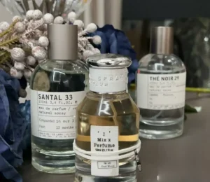 Side-by-side comparison of a traditional luxury designer perfume bottle and a minimalist everyday alternative.