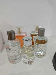 Imixx Perfumes No. 30 bottle next to a high-end designer fragrance, highlighting the minimalist packaging of affordable Berlin Maiden dupes.