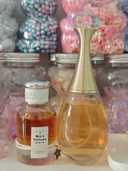 Side-by-side comparison of a luxury designer floral fragrance and a high-quality Dior J'adore dupe focusing on packaging and retail cost.