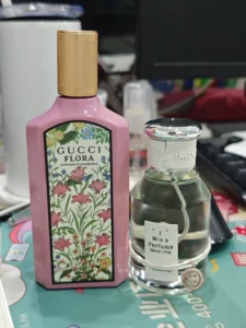 Side-by-side comparison of a $150 designer Gucci Flora Gorgeous Gardenia bottle and a high-concentration, affordable perfume alternative.