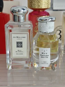 Side-by-side comparison of Jo Malone Wild Bluebell cologne and a high-concentration EDP alternative showing fragrance color differences.