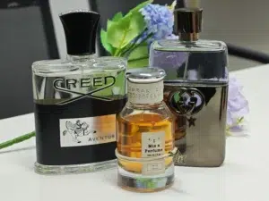 comparison of a $300 luxury niche fragrance bottle next to a high-quality Creed Acqua Fiorentina dupe from a factory-direct brand.