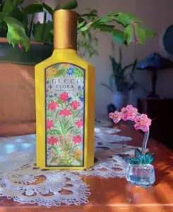Side-by-side comparison of the designer Gucci Flora Gorgeous Orchid perfume bottle and a premium, lab-verified Extrait de Parfum alternative.