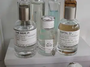 Visual breakdown showing the formulation and longevity differences between an expensive Santal 33 designer fragrance and an affordable long-lasting dupe.