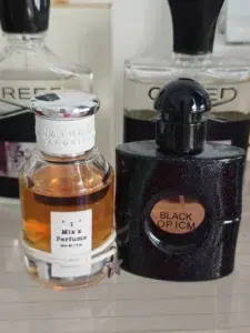Side-by-side packaging and cost comparison of a $150 luxury designer perfume versus a high-concentration Black Opium alternative.