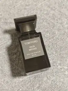 Luxury oud perfume compared with a budget-friendly woody fragrance in a side-by-side bottle comparison